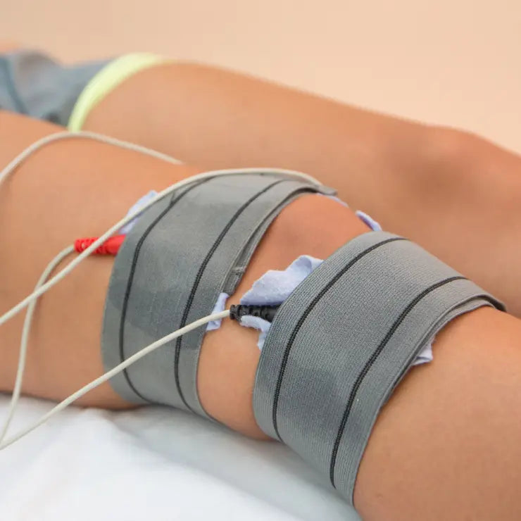 A person's knee with electrodes attached for medical monitoring