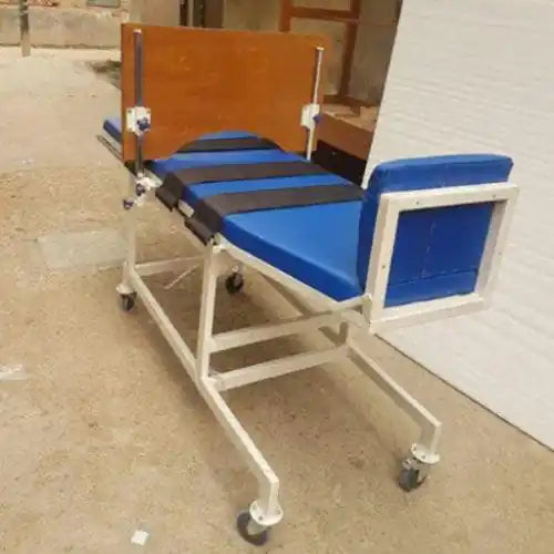 Blue and black medical stretcher on wheels with wooden backrest in an outdoor setting.