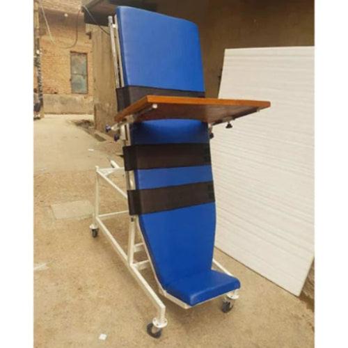 Blue adjustable chair with a wooden table on wheels in an outdoor setting.