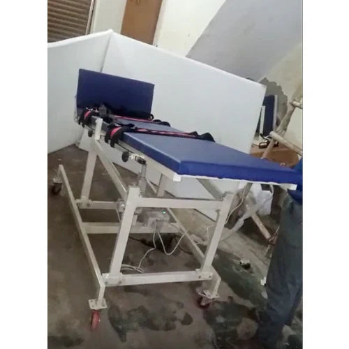 Blue and white medical examination table in a room with a window.